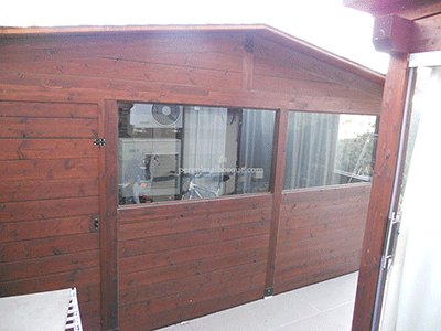 caseta de madera grande, con cerramientos acristalados