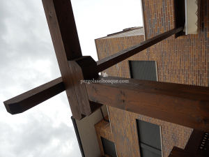 detalle de estructura de pergola en madera de roble con acabado oscuro