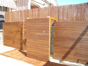 valla de separación de duchas y lavabos en exterior, hecha de madera